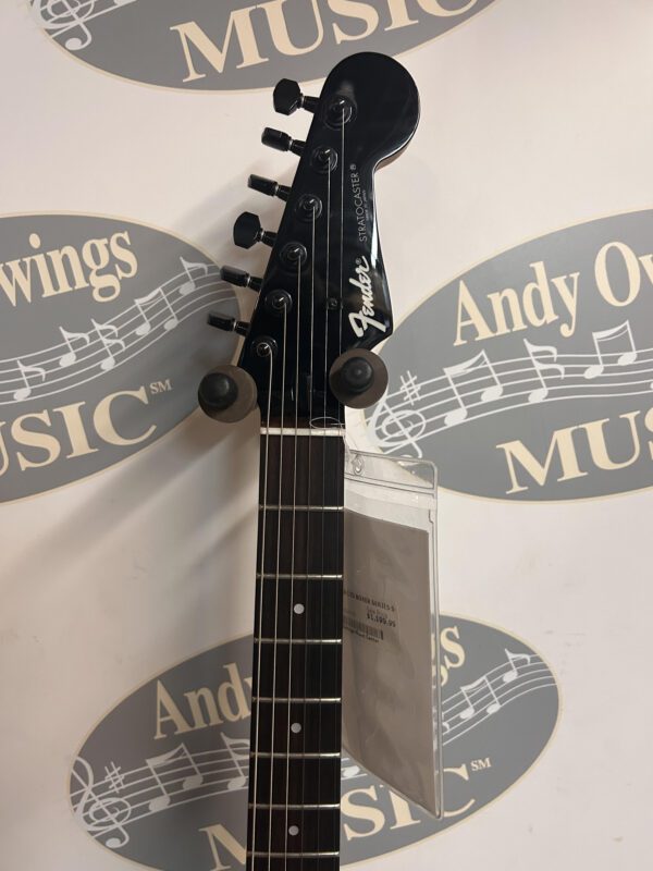 A black guitar with a label on it.