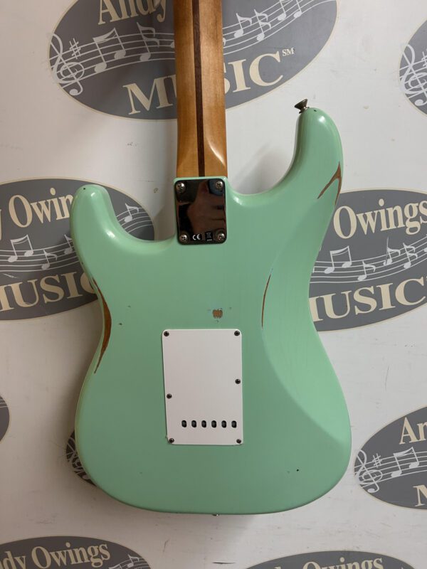A green electric guitar with a logo on it.