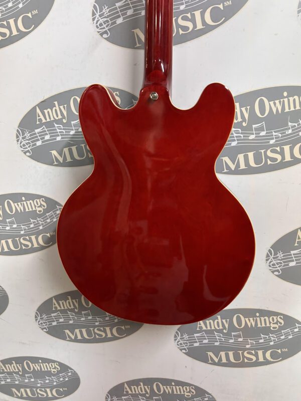 A red electric guitar with a logo on it.