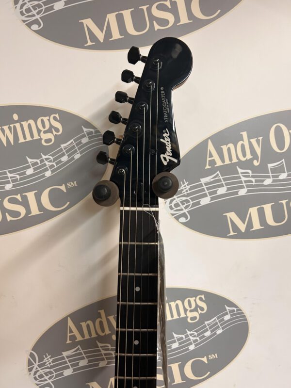 A black guitar with a logo on it.