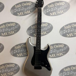 A silver electric guitar with a logo on it.
