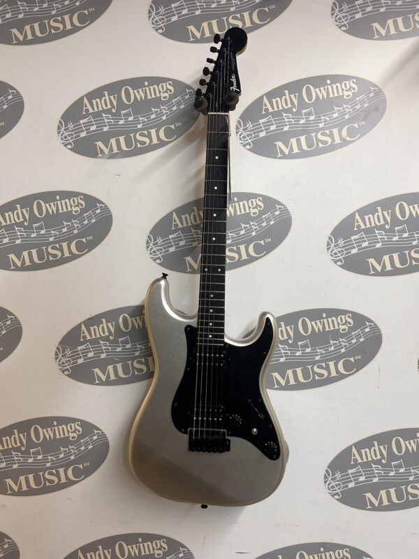 A silver electric guitar with a logo on it.