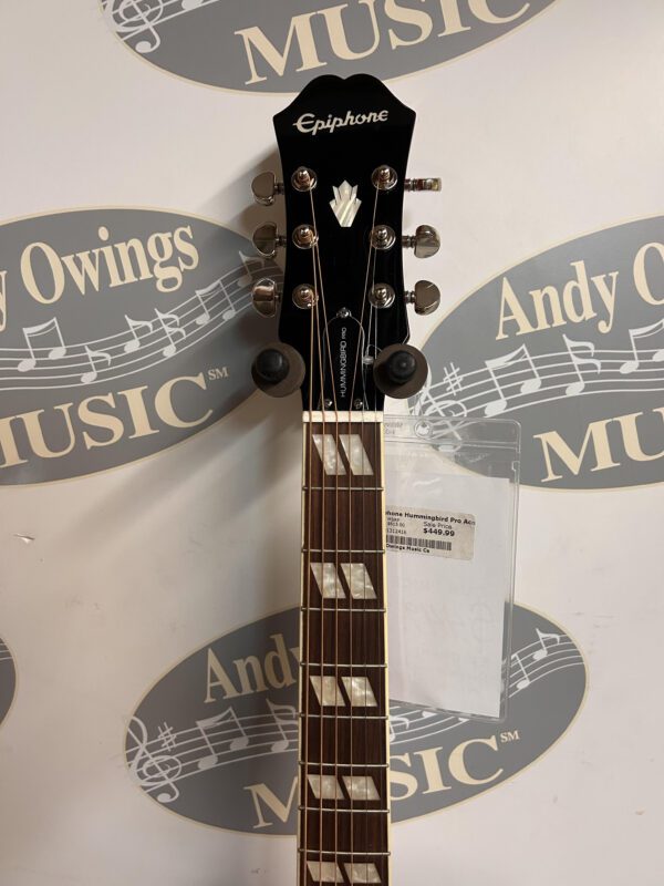 An Epiphone HummingBird Pro guitar with a logo on it.