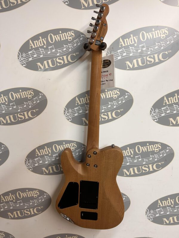 A brown guitar with a tag on it.